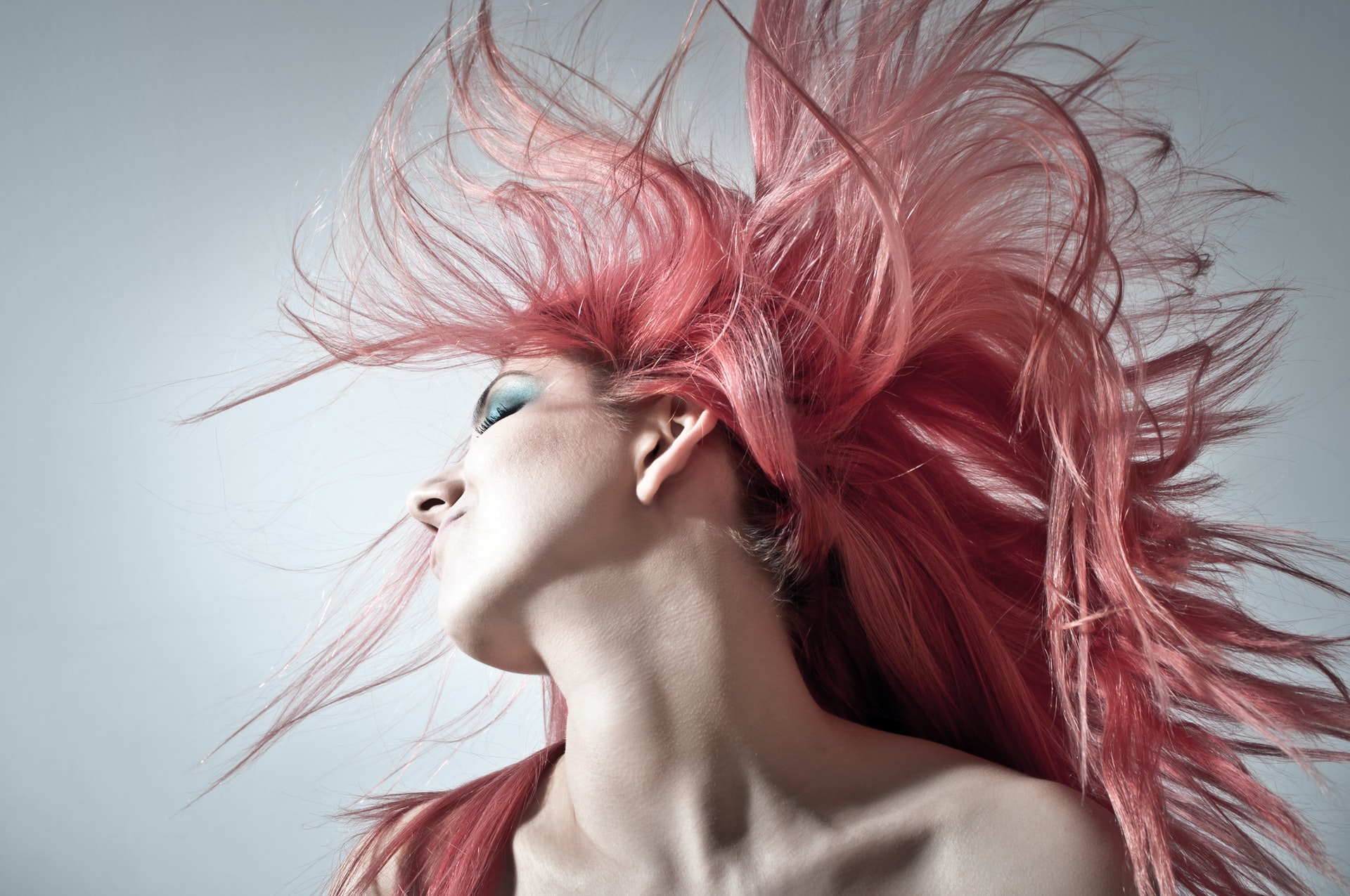 pink haired woman tosses head back